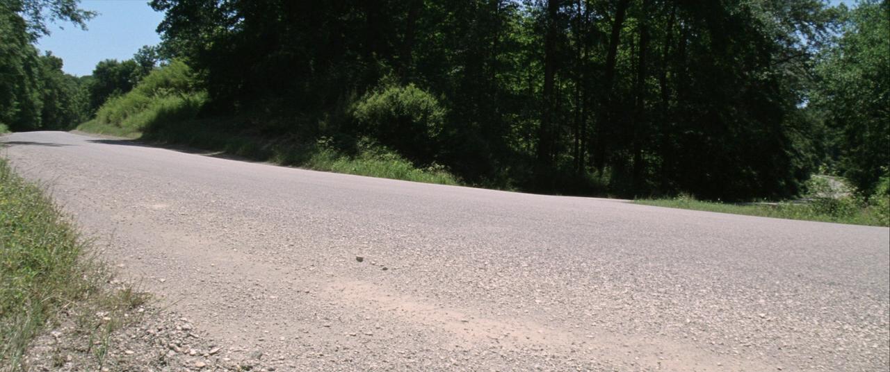 Loose chip-seal gravel on a rural Ozark county road in Northwest Arkansas